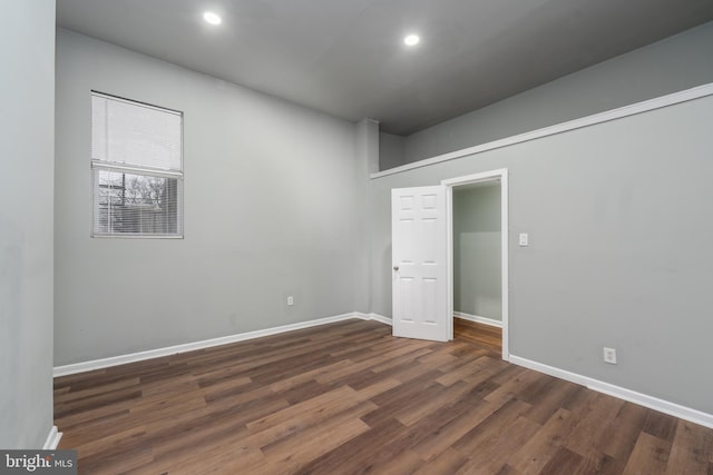 unfurnished room with dark wood-type flooring