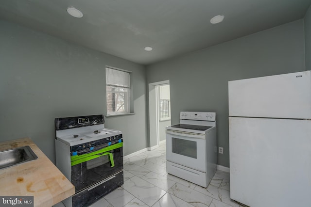 kitchen featuring light tile floors, white appliances, and sink