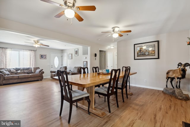 dining space featuring wood-type flooring and ceiling fan