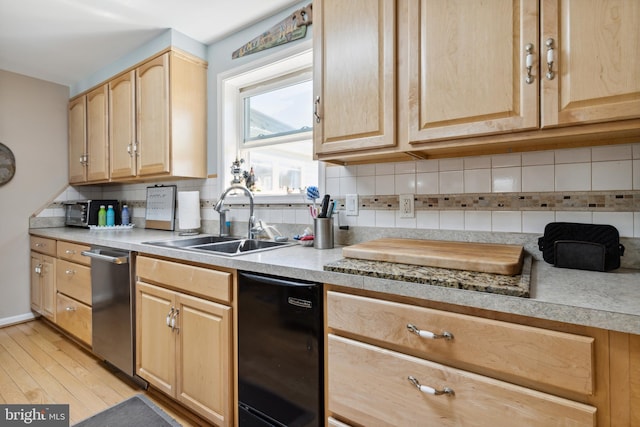 kitchen with light hardwood / wood-style floors, stainless steel dishwasher, sink, and tasteful backsplash