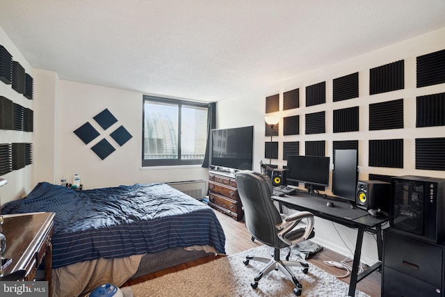 bedroom featuring light hardwood / wood-style flooring and a textured ceiling