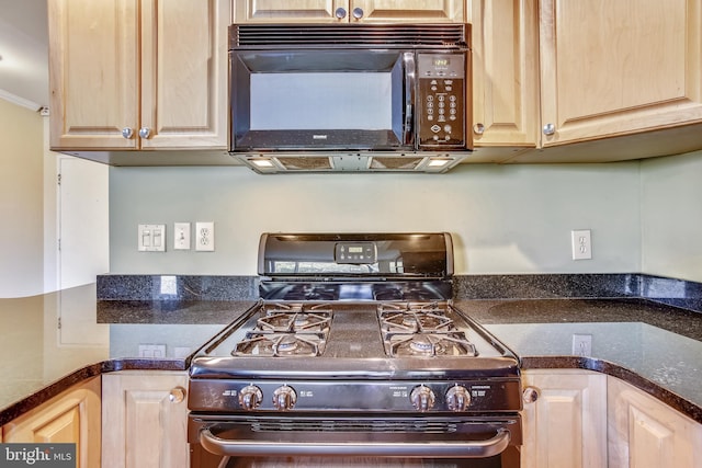 kitchen featuring light brown cabinetry, ornamental molding, gas stove, and dark stone countertops