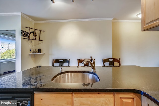 kitchen featuring dishwashing machine, light brown cabinetry, sink, and dark stone counters