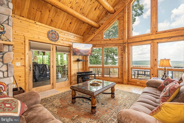 living room with hardwood / wood-style floors, beamed ceiling, wood ceiling, high vaulted ceiling, and wood walls