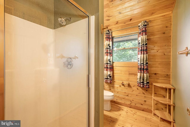 bathroom featuring wooden walls, toilet, and walk in shower