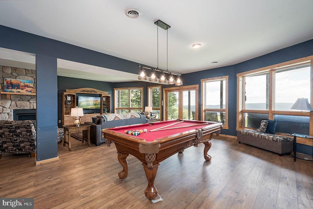 rec room with a stone fireplace, billiards, and hardwood / wood-style flooring