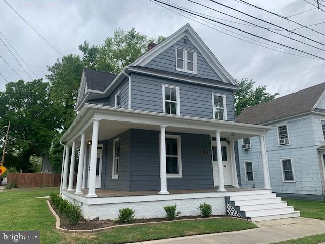 view of front of home featuring covered porch and a front lawn