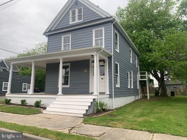 view of front of house with a porch and a front yard