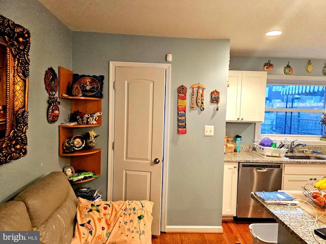 kitchen featuring white cabinetry, light hardwood / wood-style floors, dishwasher, and sink