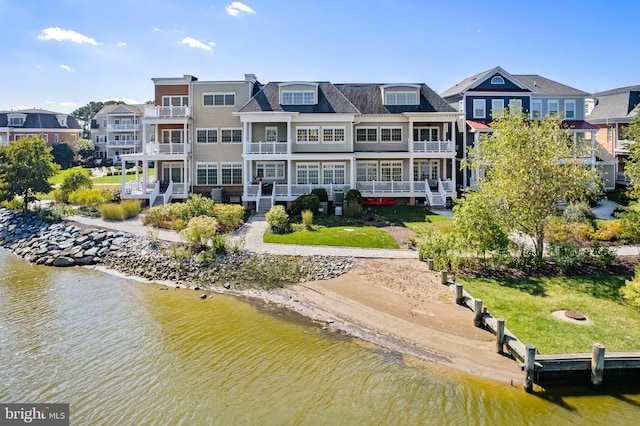 rear view of property with a balcony and a water view