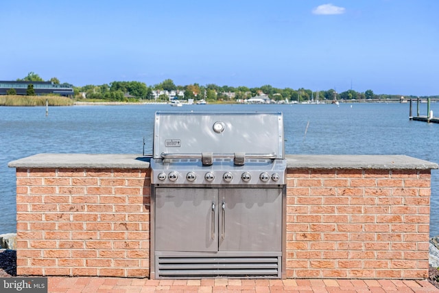 view of patio / terrace with a water view and a grill