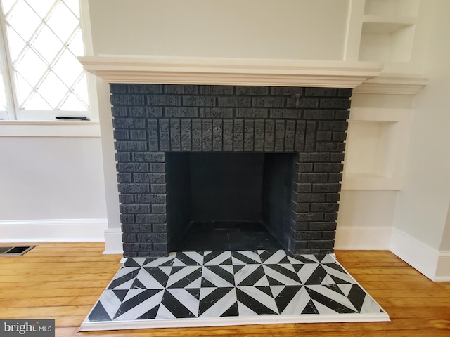 room details with a brick fireplace and hardwood / wood-style flooring