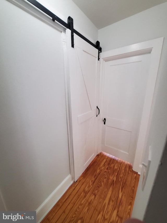 interior space with dark hardwood / wood-style flooring and a barn door