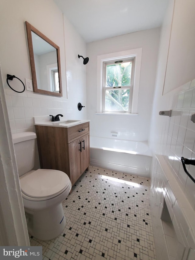 full bathroom featuring toilet, vanity, tile walls, backsplash, and tile floors