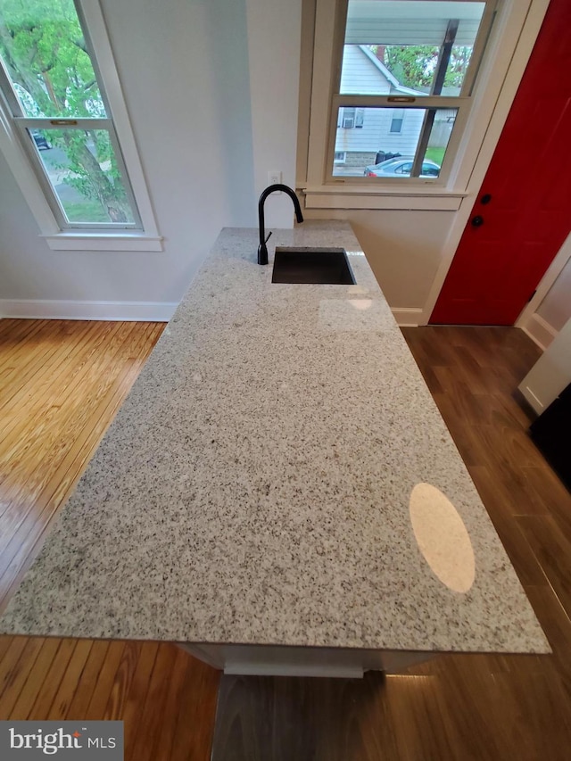 interior space featuring light stone countertops, dark wood-type flooring, and sink