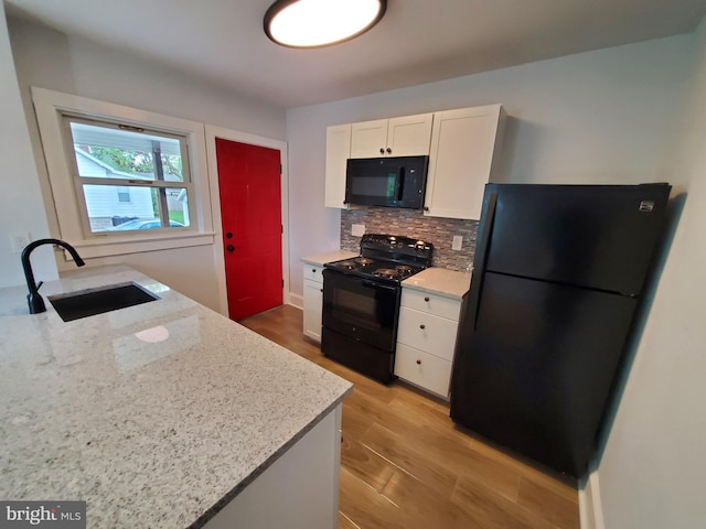 kitchen featuring tasteful backsplash, sink, light stone countertops, black appliances, and white cabinets