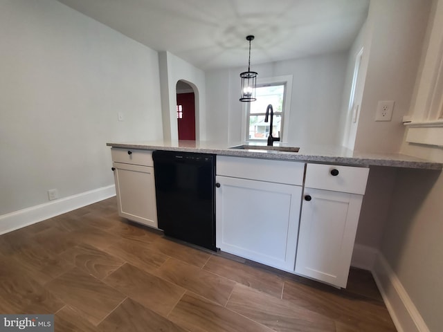 kitchen with pendant lighting, light stone counters, sink, black dishwasher, and white cabinets