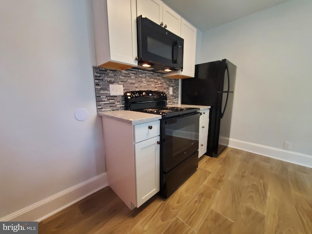 kitchen with light wood-type flooring, white cabinetry, and black appliances