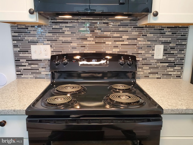 kitchen featuring backsplash, electric stove, and white cabinets