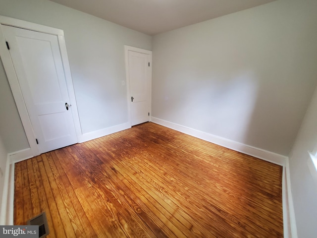 unfurnished room with dark wood-type flooring