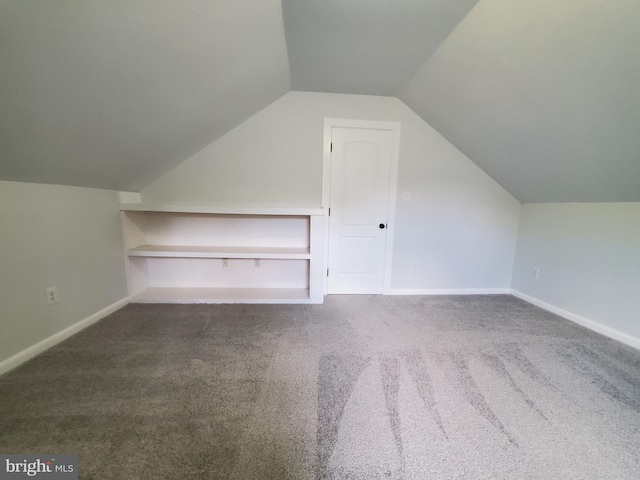 bonus room featuring dark carpet and lofted ceiling