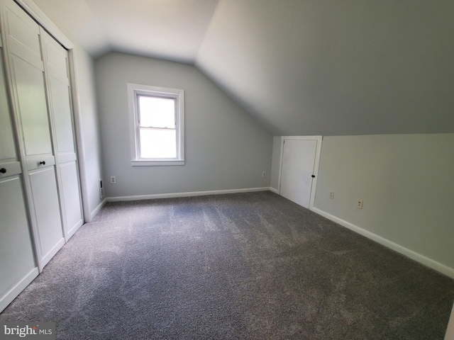 bonus room with light carpet and vaulted ceiling