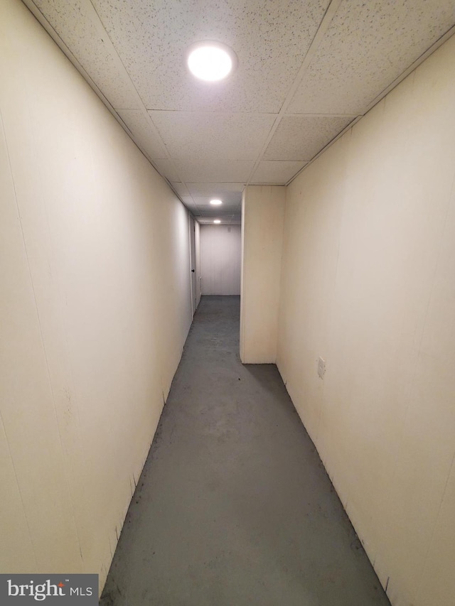 hallway featuring concrete floors and a drop ceiling