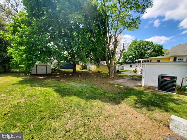 view of yard featuring a storage shed, central air condition unit, and a patio area