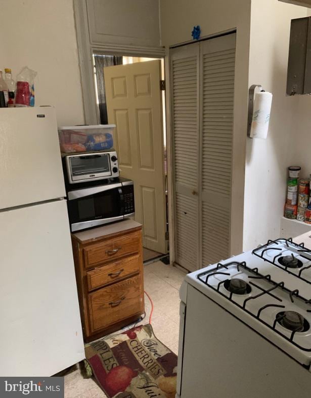 kitchen with light tile flooring and white appliances