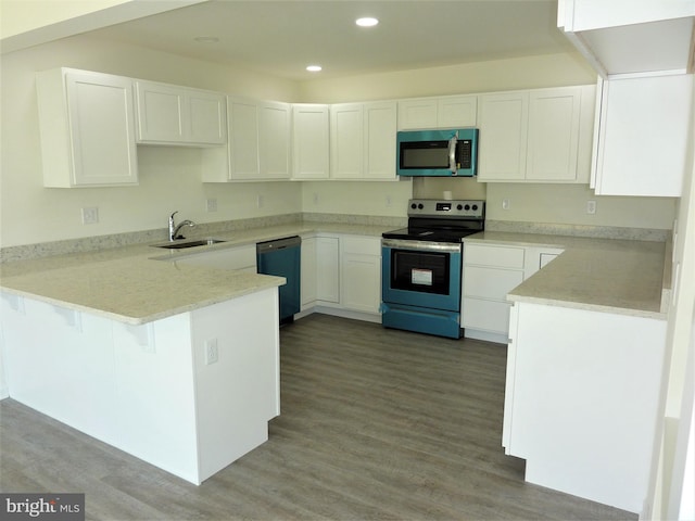 kitchen featuring kitchen peninsula, white cabinetry, wood-type flooring, sink, and stainless steel appliances