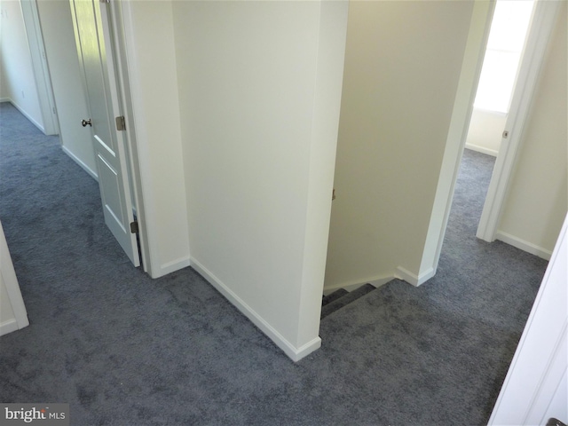 corridor featuring dark carpet