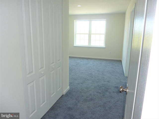 hallway featuring dark carpet