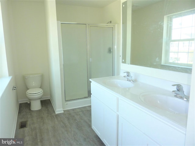 bathroom with toilet, a shower with door, dual bowl vanity, and hardwood / wood-style floors