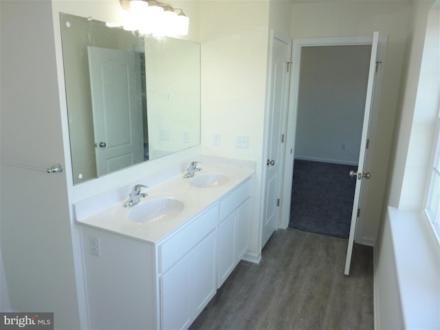 bathroom with vanity with extensive cabinet space, double sink, and wood-type flooring