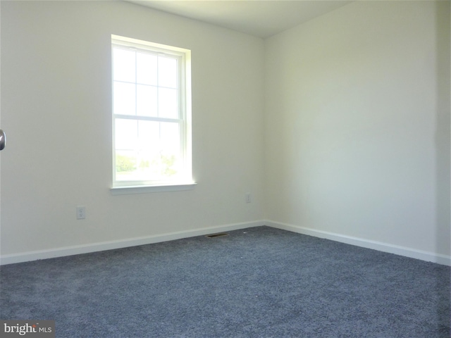 unfurnished room featuring dark carpet