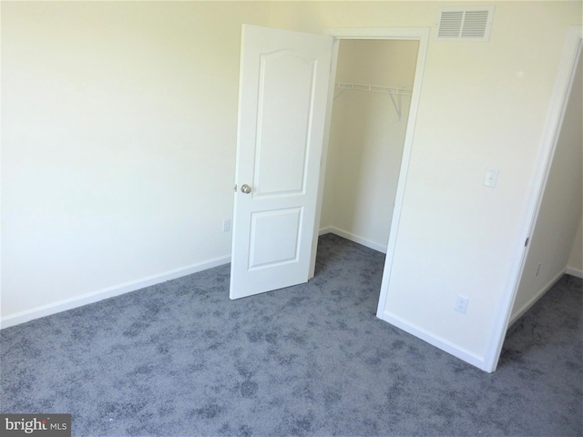 unfurnished bedroom with a closet and light colored carpet