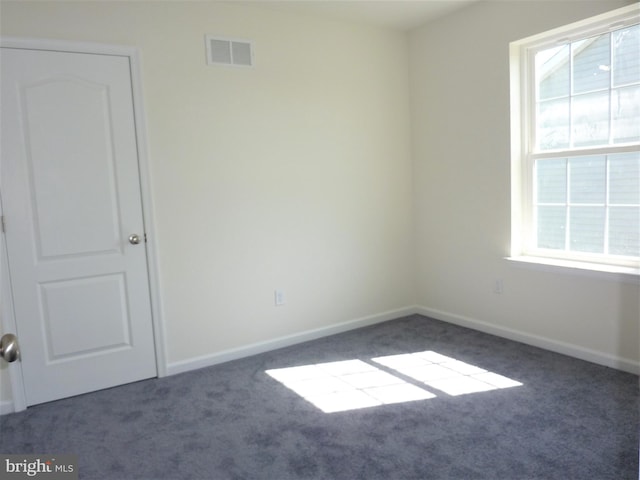 empty room with dark colored carpet