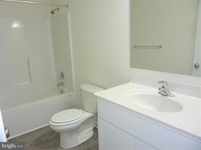 full bathroom with large vanity, wood-type flooring, toilet, and bathing tub / shower combination