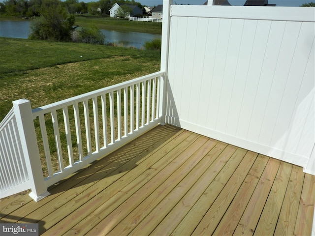 wooden deck with a water view and a yard