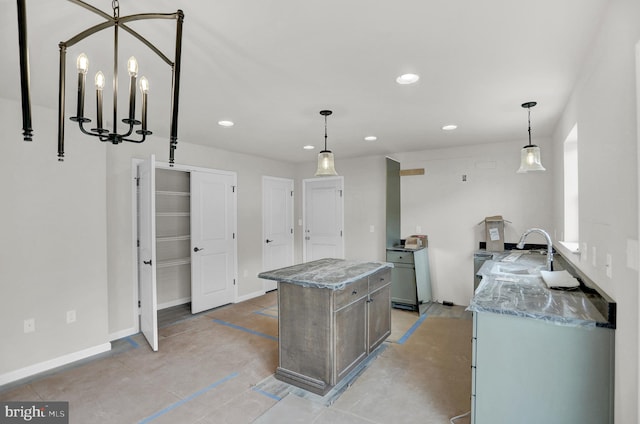 kitchen with a chandelier, pendant lighting, sink, and light stone counters