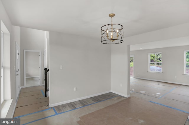 unfurnished room featuring light tile floors and a chandelier