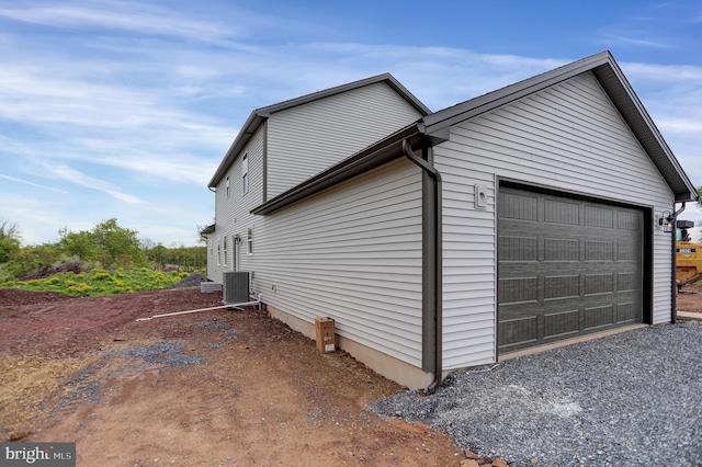 view of home's exterior with a garage and central AC unit