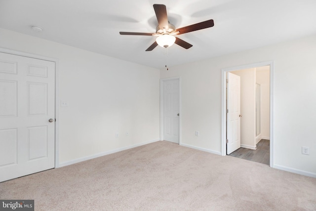 carpeted spare room featuring ceiling fan