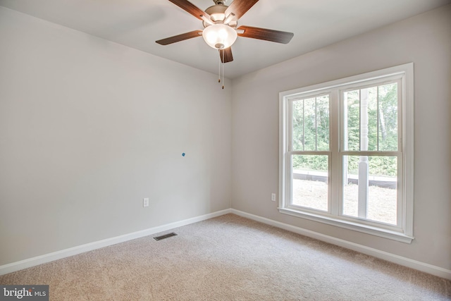 unfurnished room featuring light carpet, ceiling fan, and plenty of natural light