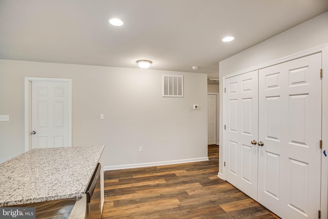 kitchen featuring dark wood-type flooring and light stone counters