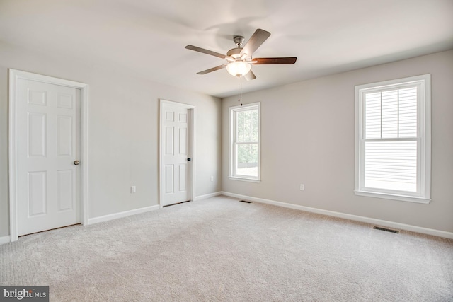 empty room with light colored carpet and ceiling fan