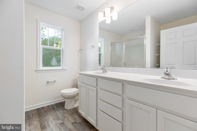 bathroom featuring hardwood / wood-style floors, vanity with extensive cabinet space, toilet, and dual sinks