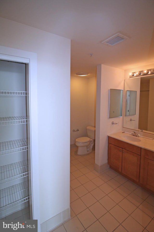 bathroom with tile patterned floors, visible vents, toilet, baseboards, and vanity