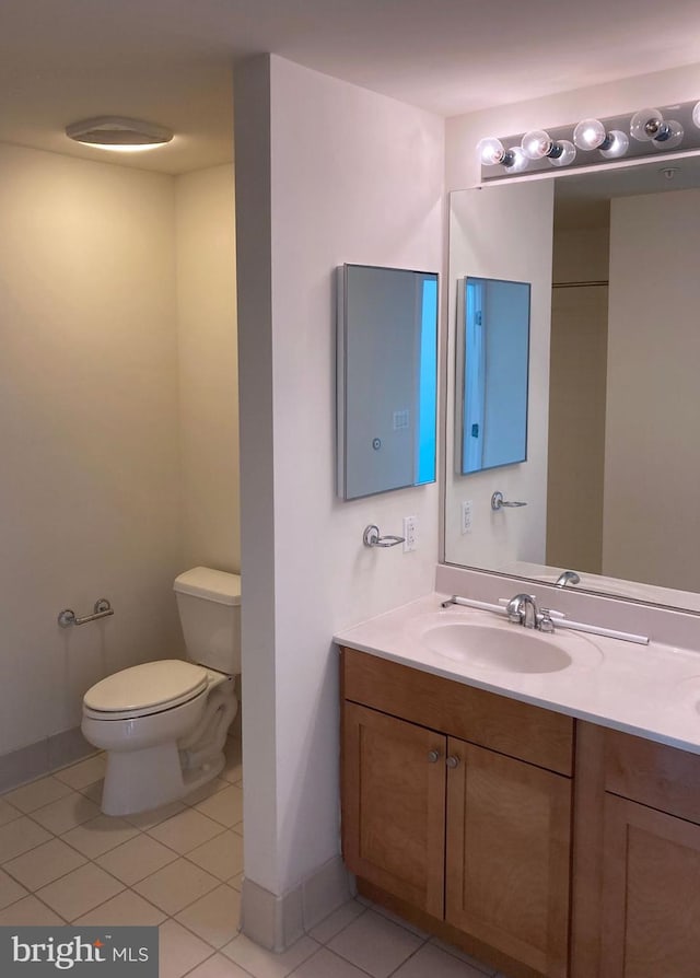 bathroom with tile patterned floors, toilet, vanity, and baseboards