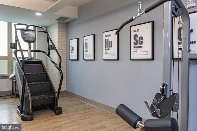 workout room with visible vents, baseboards, and wood finished floors